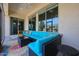 Covered patio featuring a large blue sectional, decorative rug, and outdoor ceiling fan at 17900 W Briarwood Dr, Goodyear, AZ 85338