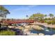 Scenic bridge over a pond with lush landscaping, rocks, and view of the surrounding community at 17900 W Briarwood Dr, Goodyear, AZ 85338