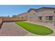 Low-maintenance backyard featuring an artificial turf area and gravel, with a brick perimeter wall at 18047 W Caribbean Ln, Surprise, AZ 85388