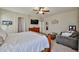 Cozy bedroom featuring a ceiling fan, TV, and sitting area with comfortable couch at 18047 W Caribbean Ln, Surprise, AZ 85388