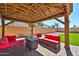Backyard gazebo featuring outdoor furniture, gas firepit and overhead lighting at 18047 W Caribbean Ln, Surprise, AZ 85388