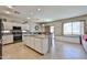 Spacious kitchen with granite island, stainless appliances, tile floors, and breakfast nook at 18047 W Caribbean Ln, Surprise, AZ 85388