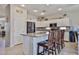 Bright kitchen features granite countertops, stainless steel appliances, and an island with bar seating at 18047 W Caribbean Ln, Surprise, AZ 85388