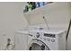 Laundry area equipped with washer, dryer, and storage shelves at 18047 W Caribbean Ln, Surprise, AZ 85388