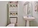 Charming powder room with decorative shelves, plants and pedestal sink at 18047 W Caribbean Ln, Surprise, AZ 85388