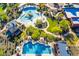 Aerial view of community pools with slides and a lap pool surrounded by umbrellas, landscaping and patio seating at 1806 W Fetlock Trl, Phoenix, AZ 85085