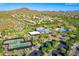 Aerial view of a clubhouse with tennis courts, pool and mountains beyond lush homes in an active community at 1806 W Fetlock Trl, Phoenix, AZ 85085