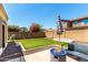 Lush backyard with artificial turf, fire pit, seating, and well-maintained landscaping at 1806 W Fetlock Trl, Phoenix, AZ 85085