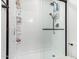 Bright bathroom shower featuring white tile, glass door, and built-in shelving at 1806 W Fetlock Trl, Phoenix, AZ 85085