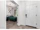 View from hallway to a bedroom with a bed with a dark green comforter and a decorative chandelier at 1806 W Fetlock Trl, Phoenix, AZ 85085