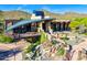 Stylish clubhouse featuring a waterfall, inviting outdoor deck and unique architecture, backed by desert landscape at 1806 W Fetlock Trl, Phoenix, AZ 85085