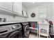 Efficient laundry room with modern washer and dryer, sink, and ample storage at 1806 W Fetlock Trl, Phoenix, AZ 85085