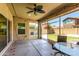 Screened-in patio featuring a ceiling fan, open to a backyard with artificial turf at 1806 W Fetlock Trl, Phoenix, AZ 85085