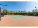 Full tennis court with net and lights amid greenery and blue sky at 1806 W Fetlock Trl, Phoenix, AZ 85085