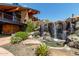 Lush waterfall feature in an outdoor space, surrounded by verdant plants and desert landscaping at 1806 W Fetlock Trl, Phoenix, AZ 85085
