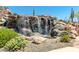 Picturesque rock waterfall with vibrant vegetation and a glimpse of a nearby playground at 1806 W Fetlock Trl, Phoenix, AZ 85085