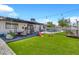 Expansive backyard with artificial grass, a pool, patio with cover, and play structures at 1914 W Onza Ave, Mesa, AZ 85202