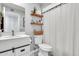 Charming bathroom with modern vanity, decorative shelves, and stylish shower curtain at 1914 W Onza Ave, Mesa, AZ 85202