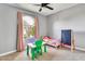 Bright bedroom featuring a ceiling fan, large window with pink curtains and carpet flooring at 1914 W Onza Ave, Mesa, AZ 85202