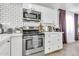 Modern kitchen featuring white cabinetry, stainless steel appliances, and stylish subway tile backsplash at 1914 W Onza Ave, Mesa, AZ 85202