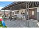 Cozy covered patio featuring comfortable seating, overhead lighting, and elegant stone flooring at 1914 W Onza Ave, Mesa, AZ 85202