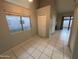 Living room with tiled floors, large window, and closet with access to the patio at 2019 W Lemon Tree Pl # 1124, Chandler, AZ 85224