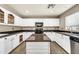 Well-lit kitchen offering ample counter space, white cabinetry, and a functional island at 21054 N Sansom Dr, Maricopa, AZ 85138