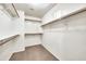Spacious walk-in closet featuring wood shelving and neutral carpeting at 21054 N Sansom Dr, Maricopa, AZ 85138