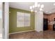 Green dining room featuring modern light fixture, window, and view into kitchen at 21059 E Pickett St, Queen Creek, AZ 85142