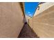 A narrow passage covered in decorative rocks on the side of the house shows the exterior wall at 21059 E Pickett St, Queen Creek, AZ 85142