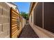 A decorative wooden wall feature on the side of the house is placed on a rock-covered passage at 21059 E Pickett St, Queen Creek, AZ 85142