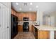Well-lit kitchen with black appliances, wood cabinets, and stone countertops at 21059 E Pickett St, Queen Creek, AZ 85142