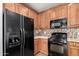 Classic kitchen featuring wood cabinets, black appliances, and stylish backsplash at 21059 E Pickett St, Queen Creek, AZ 85142