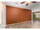 Living room space with wood-look flooring, bright windows, and a ceiling fan at 21059 E Pickett St, Queen Creek, AZ 85142