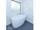 Modern bathroom features freestanding soaking tub, tiled walls and flooring, and stylish fixtures at 214 W Ruth Ave, Phoenix, AZ 85021