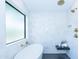 A bright bathroom featuring a modern tub, with gold fixtures and white tiled walls at 214 W Ruth Ave, Phoenix, AZ 85021
