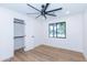 Bright bedroom featuring hardwood floors, a modern ceiling fan, window view, and walk-in closet at 214 W Ruth Ave, Phoenix, AZ 85021
