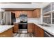 Modern kitchen with stainless steel appliances, white countertops, and wooden cabinets at 2223 E Crest Ln, Phoenix, AZ 85024