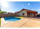 Backyard pool with concrete patio, well-kept yard, and partial shade structure at 2223 E Crest Ln, Phoenix, AZ 85024