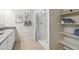 Clean bathroom includes a neutral tiled floor, framed botanical prints, open storage, and a shower with a curtain at 22570 N Lynn St, Maricopa, AZ 85138