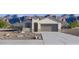 Charming single-story home featuring neutral stucco, a two-car garage and desert landscaping, set against a mountain backdrop at 22570 N Lynn St, Maricopa, AZ 85138