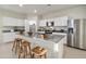 Bright kitchen features stainless steel appliances, a large island with bar stool seating, and white cabinets at 22570 N Lynn St, Maricopa, AZ 85138