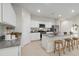 Modern kitchen featuring white cabinets, granite countertops, stainless steel appliances, and island seating at 22570 N Lynn St, Maricopa, AZ 85138