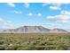Vast desert landscape featuring native plants and distant mountains under a bright, partly cloudy sky at 22570 N Lynn St, Maricopa, AZ 85138