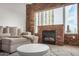 Cozy living room with a brick fireplace, sectional sofa, and large windows showcasing city views at 2302 N Central Ave # 206, Phoenix, AZ 85004