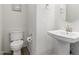Clean half bathroom with pedestal sink, toilet, and neutral wall decor at 24733 N 96Th Ln, Peoria, AZ 85383