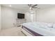 Cozy bedroom with large bed, ceiling fan, and dresser with television at 24733 N 96Th Ln, Peoria, AZ 85383