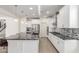 Modern kitchen featuring an island with granite countertops, stainless appliances, and white cabinetry at 24733 N 96Th Ln, Peoria, AZ 85383