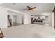 Bright living room features a ceiling fan, neutral carpet, and easy access to the kitchen and staircase at 24733 N 96Th Ln, Peoria, AZ 85383