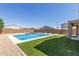 Sparkling backyard pool with tanning ledge surrounded by lush turf and gravel at 24733 N 96Th Ln, Peoria, AZ 85383